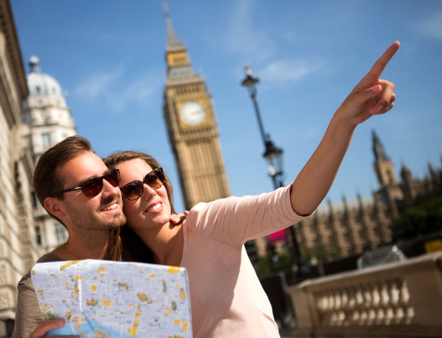 Happy summer tourists in London holding a map