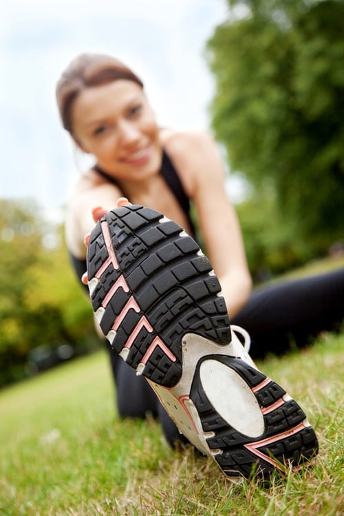 Beautiful woman doing gym stretches on the grass outdoors