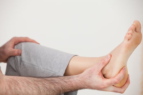 Chiropractor holding the heel of a patient in a room-1