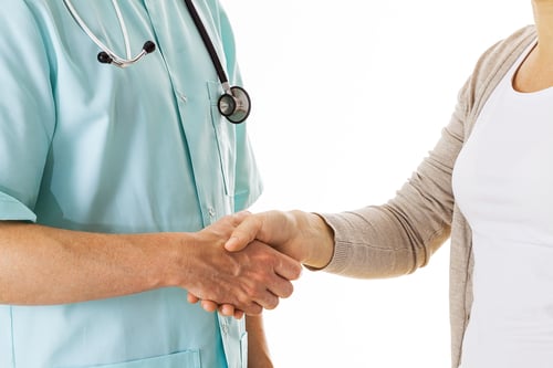 Doctor shaking hand with a patient, isolated background
