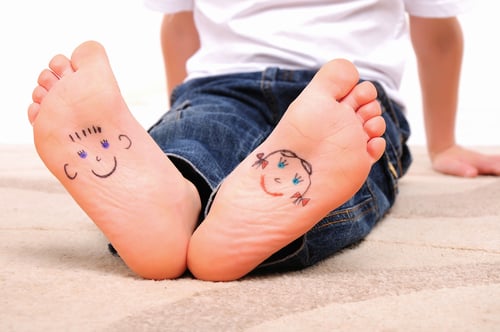 bottoms of feet with smiley faces drawn on them