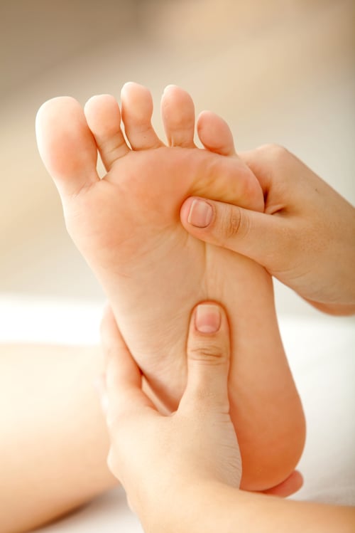 person relaxing getting a massage on the foot