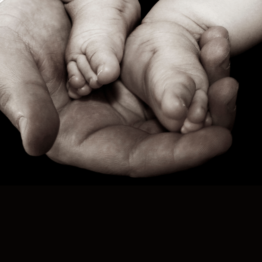 hand holding baby feet with crossover toes