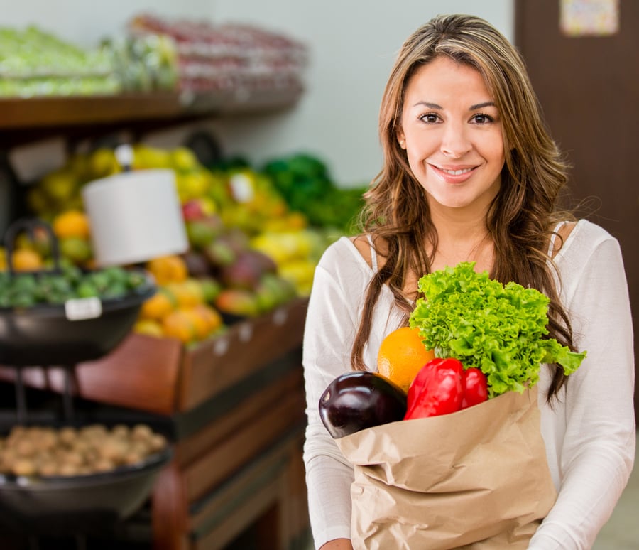 woman holding bag of fruits and vegetables