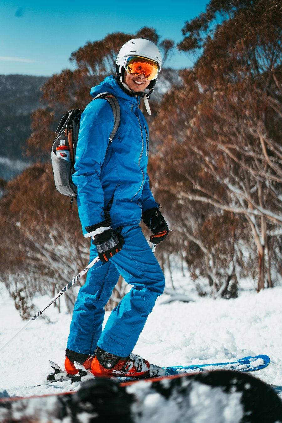 person walking in the snow with a blue snowsuit on