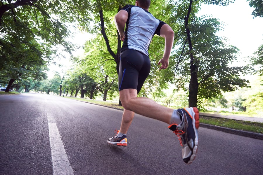 healthy athlete man jogging at morning on empty roat in the city