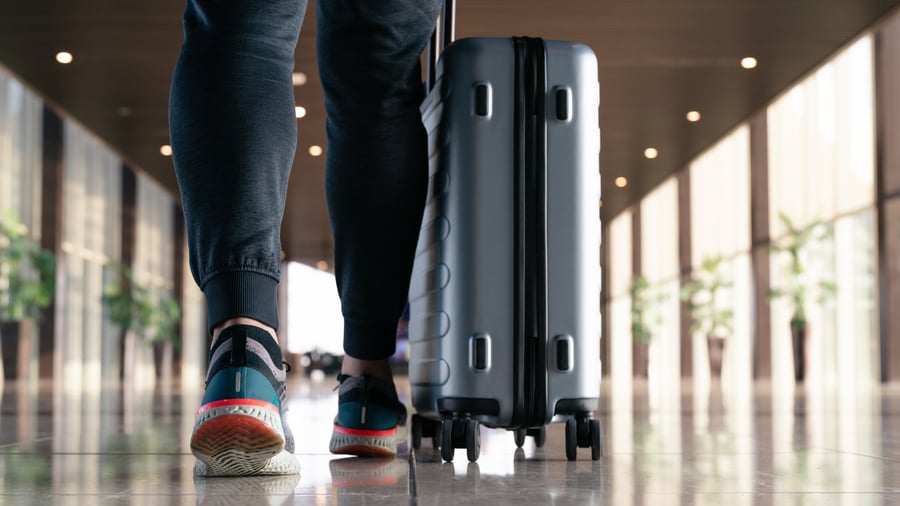 Traveler with suitcase walking through the airport terminal