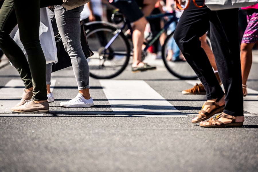 People walking across a busy walkway in city
