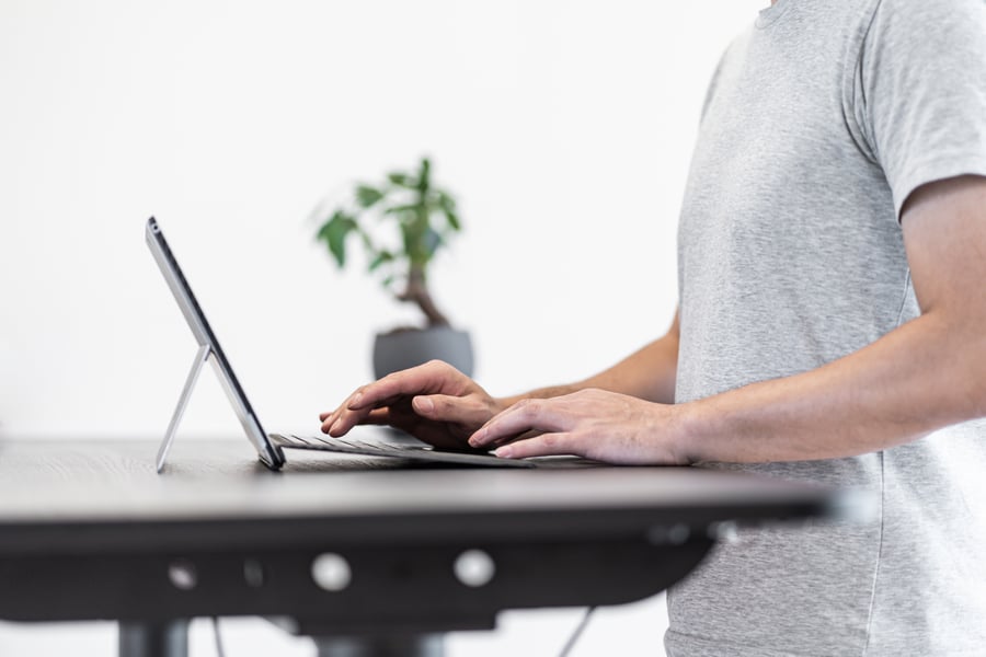 Man working remotely at standing desk in home office
