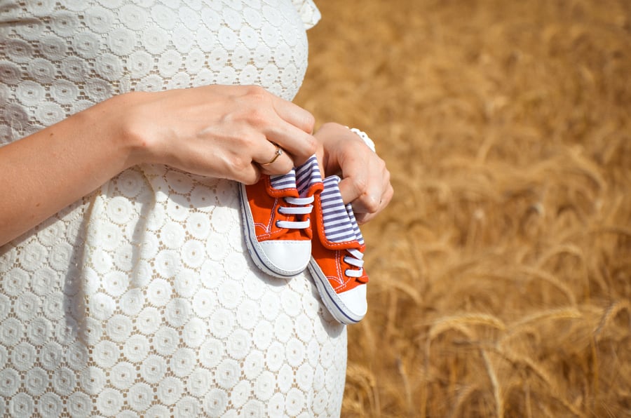 Sweeney Foot and Ankle Pregnancy and Feet Profile of Pregnant Woman Holding Red Baby Shoes on Belly